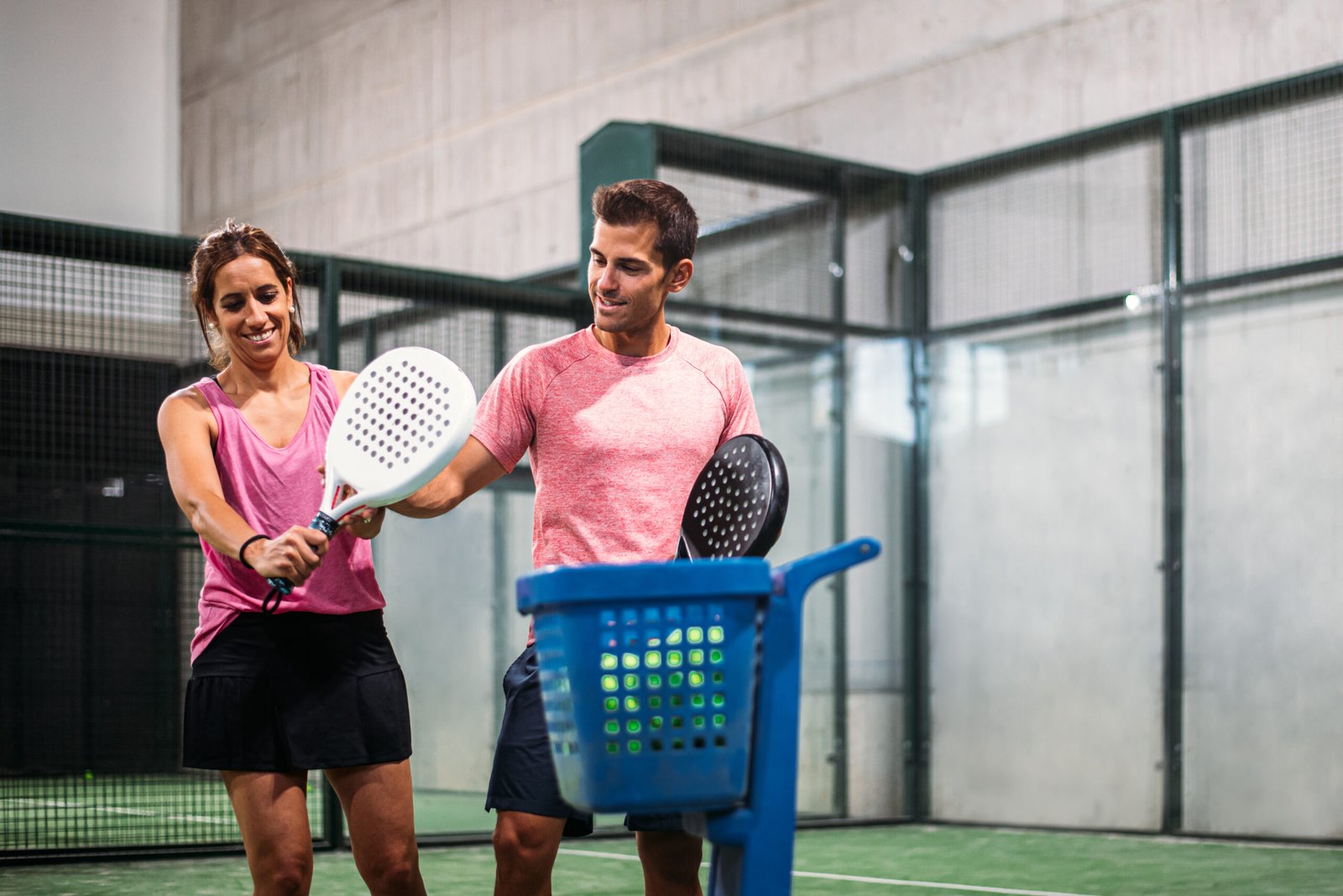 Monitor teaching padel class to woman